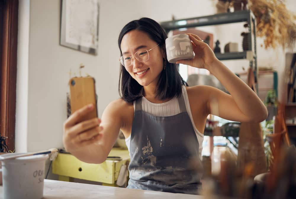 An artist takes a selfie with a mug