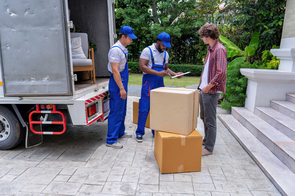 Two moving company workers with a customer