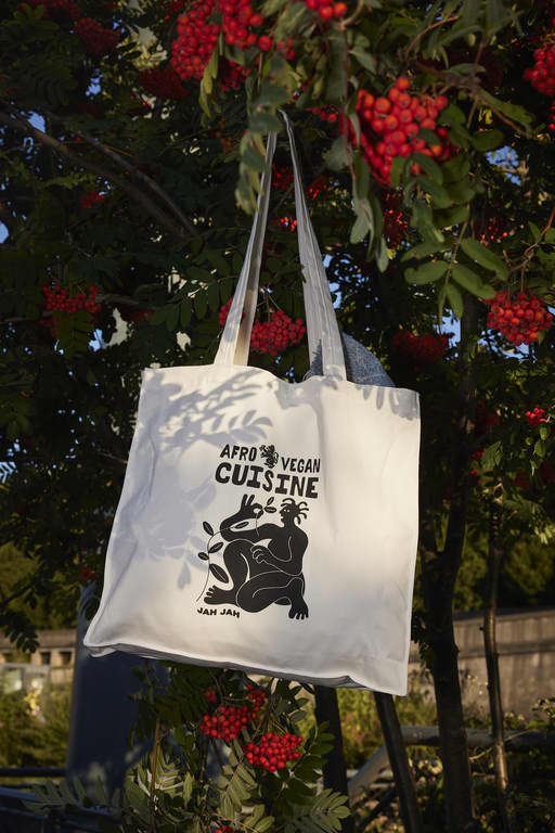 A branded tote bag hanging from a tree