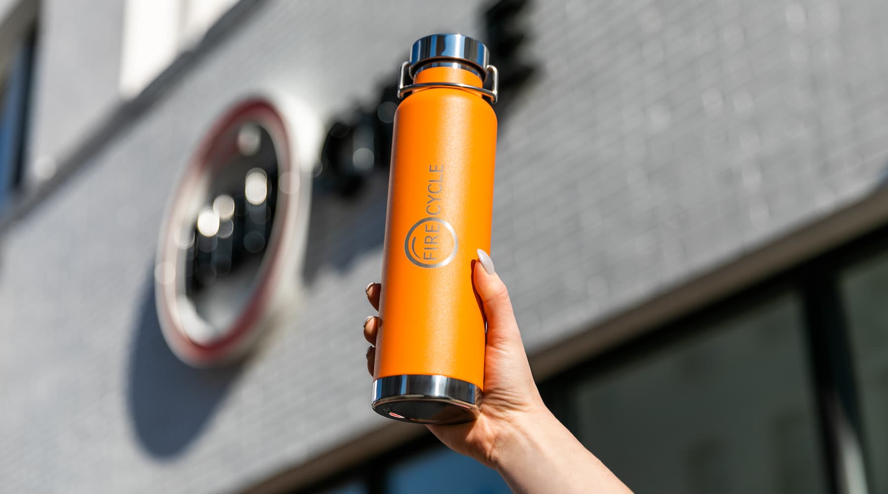 A person holds up a custom water bottle from a gym